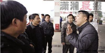 昨日,万家丽北路一加油站内, 加油站负责人(右)在和的哥们进行沟通。 图/记者秦楼