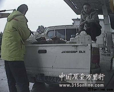 中石油员工在往23个塑料大桶内加油。 中石油员工在往23个塑料大桶内加油。