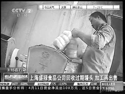 工人正往和面机里加过期的馒头。电视截屏