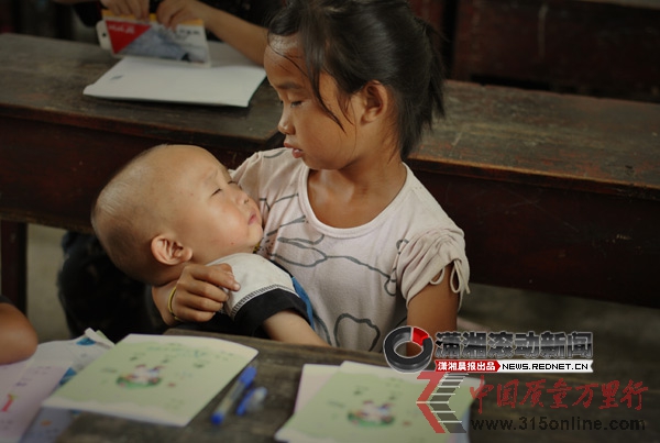 点图查看下一页 湖南留守女童带弟弟上学边听课边哄其睡觉(组图)
