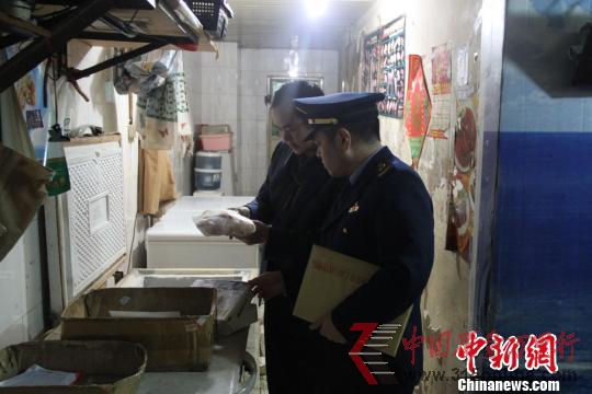 执法人员在水产店内检查。 韩璐 摄 执法人员在水产店内检查。 韩璐 摄
