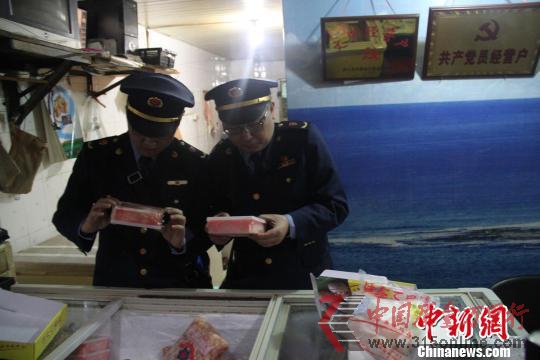 执法人员检查水产店冰柜。 韩璐 摄 执法人员检查水产店冰柜。 韩璐 摄
