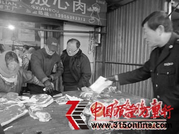 执法人员在市场上检查“两证”。本报记者 孙芳芳 摄