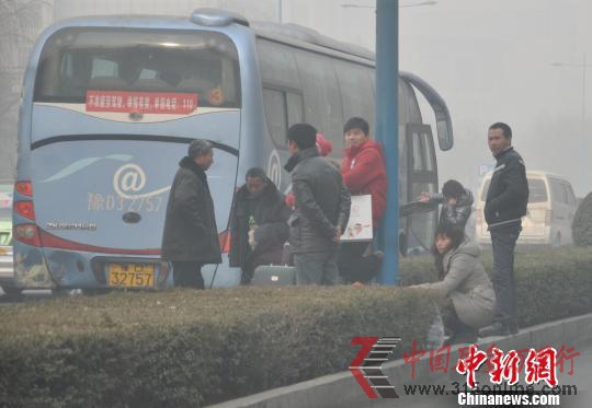 一辆长途客车在站外为乘客装行李。 一辆长途客车在站外为乘客装行李。