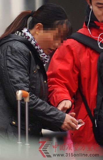 一位旅客在杭州火车南站给“吴大姐”100元后,被领进车站。 新华社 图 一位旅客在杭州火车南站给“吴大姐”100元后,被领进车站。 新华社 图