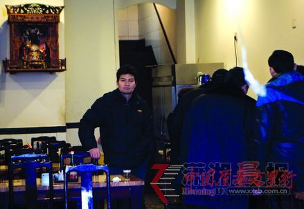 工作人员在忙着签写整改通知书,门店老板李明生站在身后一脸苦闷。图/记者辜鹏博