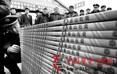 图为工商执法人员清点假冒石膏板