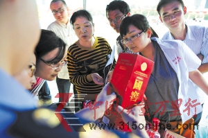 近日,工商执法人员正在向市民介绍真假国窖1573的辨别方法。贺文兵 摄 近日,工商执法人员正在向市民介绍真假国窖1573的辨别方法。贺文兵 摄