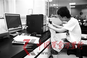 工作人员正在把防晒衣放入仪器内检测 工作人员正在把防晒衣放入仪器内检测