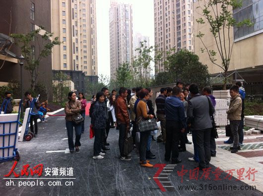 业主们围在小区门口讨说法。 业主们围在小区门口讨说法。