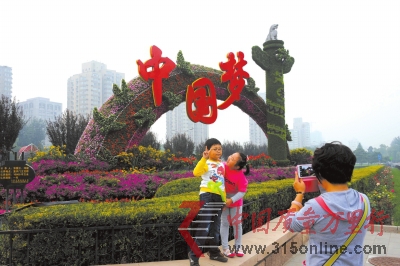 市民在复兴门桥“放飞梦想”花坛前留念。昨天,长安街沿线花坛摆放工作全部完成。京华时报记者徐晓帆摄